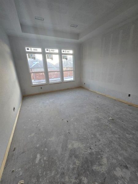 Empty room with concrete flooring and a raised ceiling