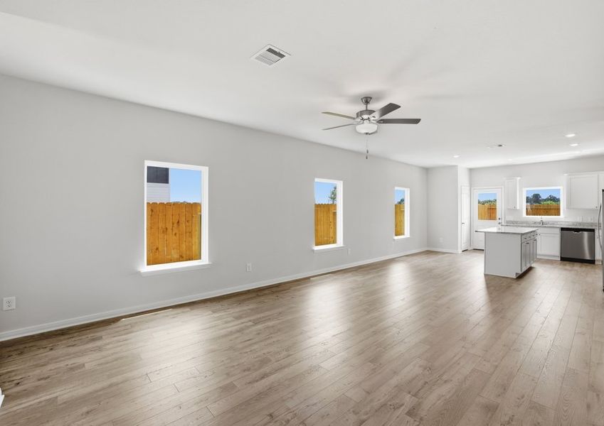 Living room featuring large windows, a ceiling fan, and wood-look flooring.