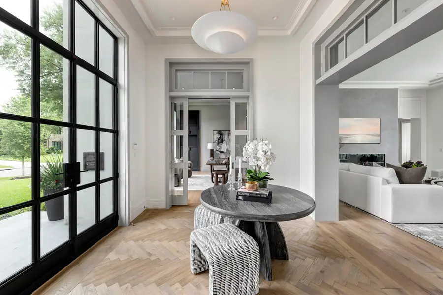 Warm and sun-drenched foyer greets your guests with floors in a herringbone pattern, an introduction to the fine craftsmanship throughout the home.