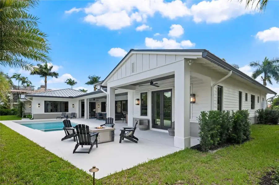 Covered patio featuring board and batten siding, recessed ceiling lighting, attached ceiling fan, and concrete hardscaping surrounding an in-ground swimming pool Covered patio featuring board and batten siding, recessed ceiling lighting, attached ceiling fan, and concrete hardscaping surrounding an in-ground swimming pool