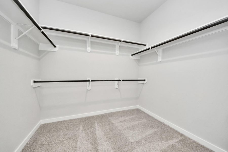 Walk-in closet that epitomizes luxury and practicality. This generously sized space features built-in shelving, offering abundant room for impeccable organization. High ceilings and recessed lighting create a bright and welcoming ambiance. Sample photo of completed home with similar floor plan. Actual colors and selections may vary. Walk-in closet that epitomizes luxury and practicality. This generously sized space features built-in shelving, offering abundant room for impeccable organization. High ceilings and recessed lighting create a bright and welcoming ambiance. Sample photo of completed home with similar floor plan. Actual colors and selections may vary.