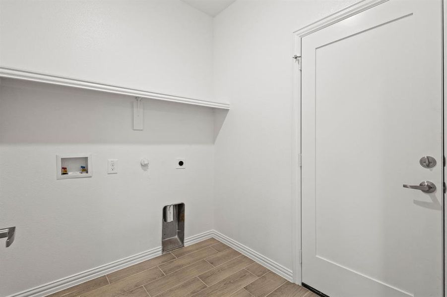 Clothes washing area featuring hookup for a gas dryer, hookup for an electric dryer, laundry area, washer hookup, and wood tiled floor