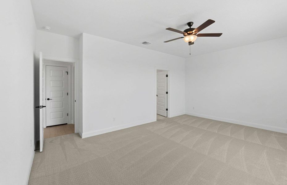 Empty room with light carpet and ceiling fan Empty room with light carpet and ceiling fan