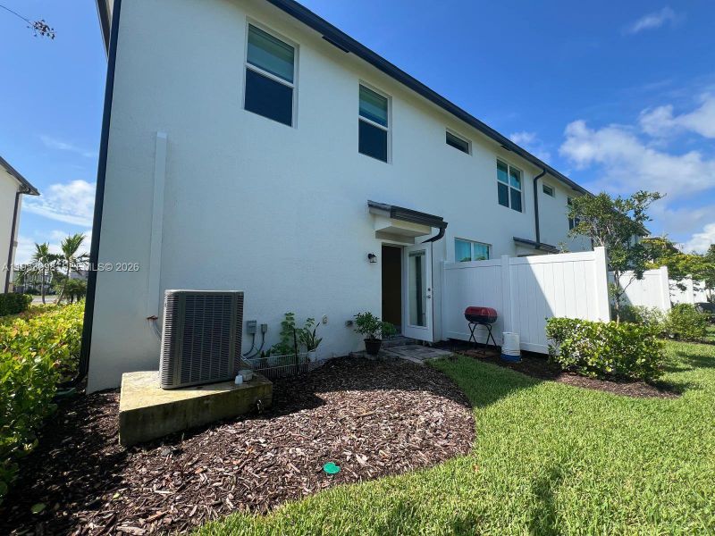 Vista posterior de la propiedad que muestra la estructura de la vivienda, el patio privado y el área exterior.