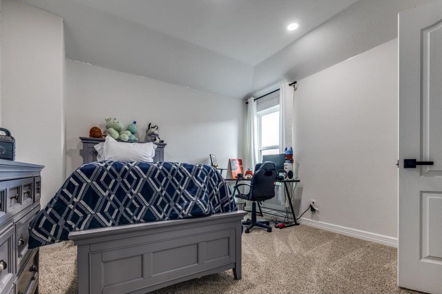 The room is well-lit with recessed lighting and has neutral-tone walls and curtains.