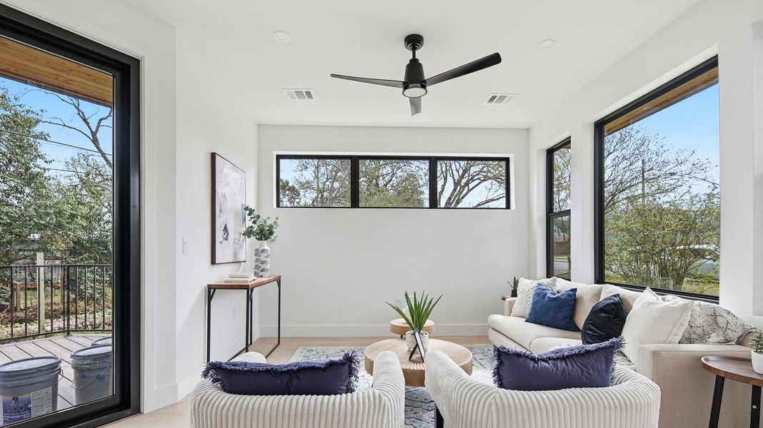 Sitting room with a ceiling fan and baseboards