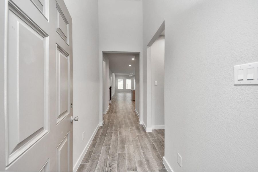 As you step into the threshold of this luxurious home, you'll soon be welcomed by an elegant glass door (to be installed). Inside, soaring ceilings amplify the spaciousness, while the refined wood-look tile flooring and oversized baseboards exude sophistication and charm. Sample photo of completed home with similar floor plan. Actual colors and selections may vary.
