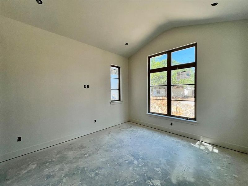 Unfurnished room with lofted ceiling and concrete flooring