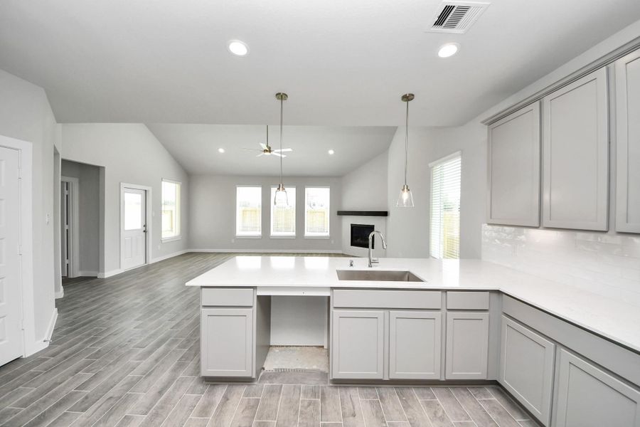 This kitchen is truly a chef's dream! This haven Boasts high ceilings, recessed & pendant lighting, stained wood cabinets, granite countertops, stainless steel appliances, a modern tile backsplash. All of this overlooks your expansive family room, creating a perfect space for culinary delights and family gatherings. Sample photo of completed home with similar floor plan. Actual colors and selections may vary. This kitchen is truly a chef's dream! This haven Boasts high ceilings, recessed & pendant lighting, stained wood cabinets, granite countertops, stainless steel appliances, a modern tile backsplash. All of this overlooks your expansive family room, creating a perfect space for culinary delights and family gatherings. Sample photo of completed home with similar floor plan. Actual colors and selections may vary.