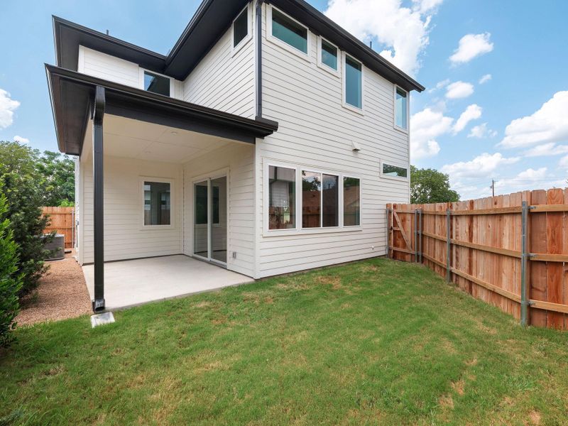A spacious covered patio provides a delightful outdoor living area overlooking a private backyard.