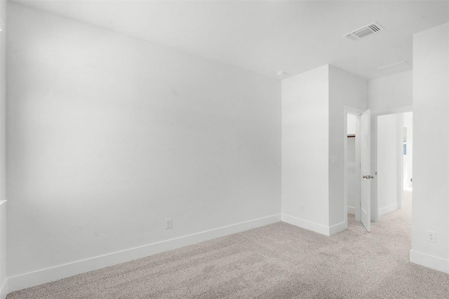 A spacious, naturally illuminated room featuring plush carpeting and pristine walls, ready for personalization.
