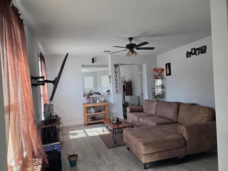 Living area featuring wood finished floors and ceiling fan