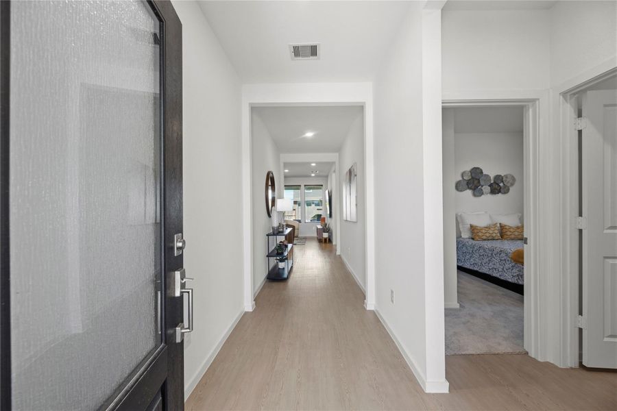 Long entry hallway with natural light and wood-look flooring.