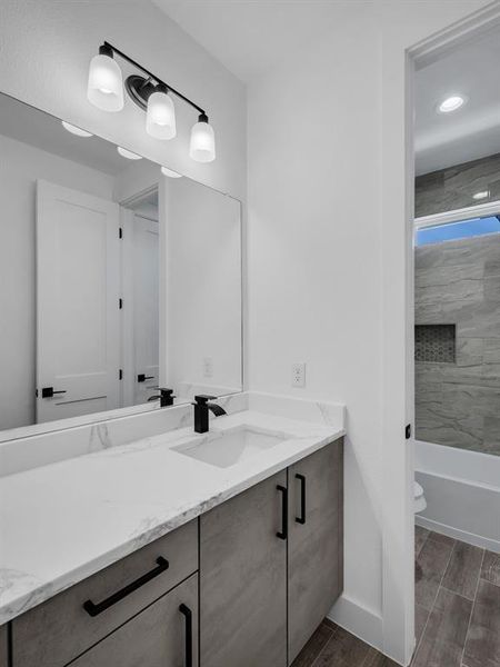 Full bathroom with vanity, tiled shower / bath, and toilet