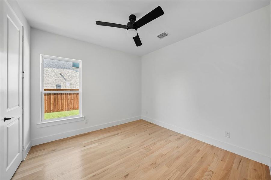 Spare room with light wood finished floors and a ceiling fan