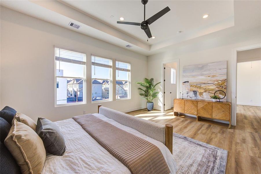 This oversized primary bedroom on the 3rd floor features a tray ceiling and tons of natural light. Includes two walk-in closets: one in the bedroom and the other in the bathroom.