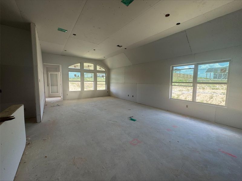 Unfurnished room featuring vaulted ceiling and concrete flooring Unfurnished room featuring vaulted ceiling and concrete flooring