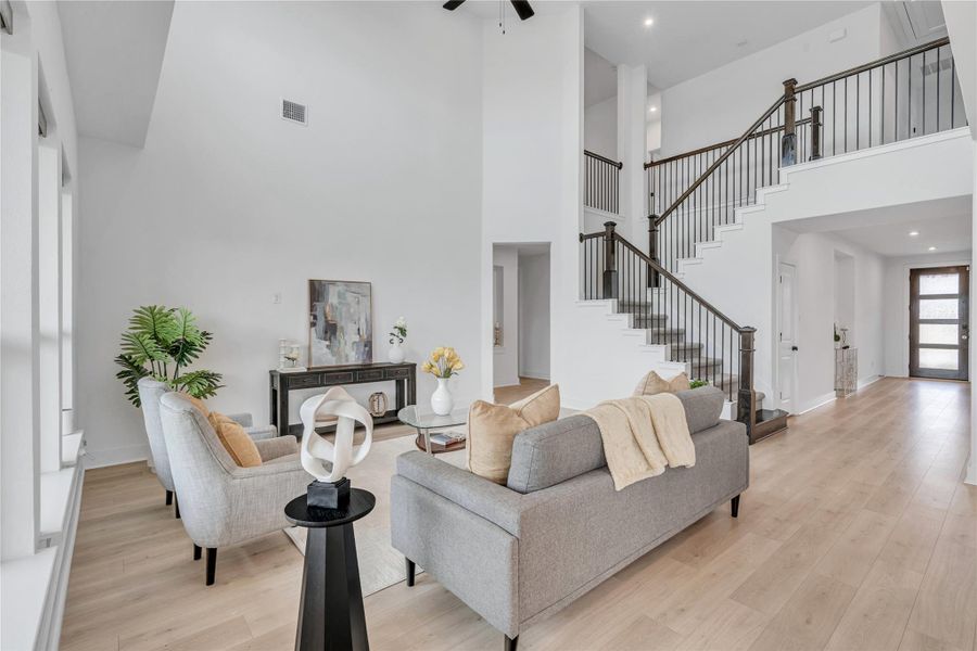 Grand two-story living area with high ceilings and an elegant staircase.