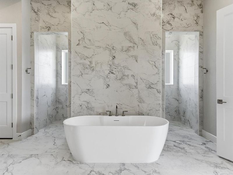 Full bath with a freestanding tub, stone wall, marble tiled flooring, plenty of natural light, and tile walls Full bath with a freestanding tub, stone wall, marble tiled flooring, plenty of natural light, and tile walls