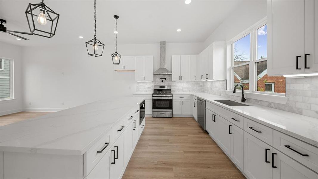 This kitchen includes under cabinet lighting and outlets, and luxury vinyl plank floors.