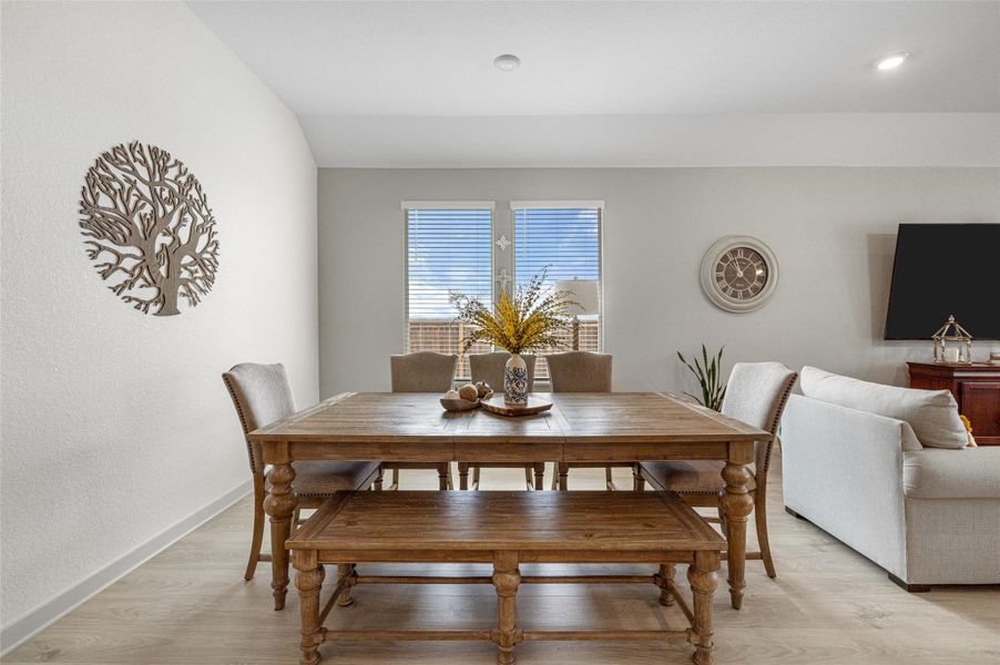 Dining space with light wood-style flooring and a textured wall Dining space with light wood-style flooring and a textured wall