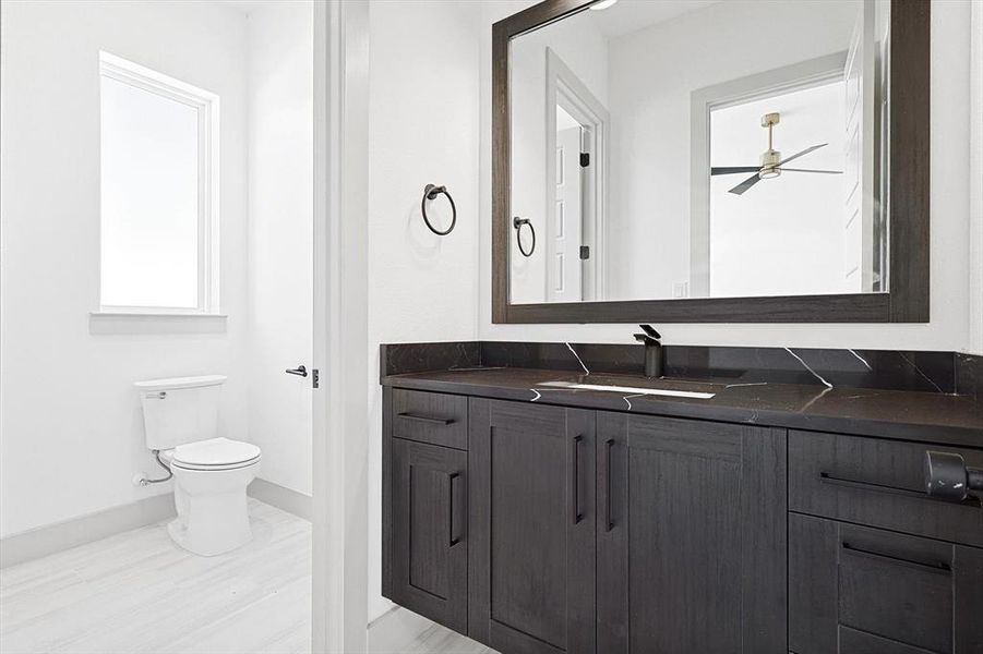 Bathroom featuring vanity, ceiling fan, and toilet