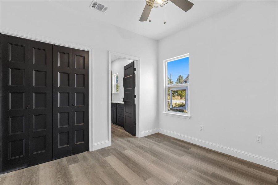 Crisp white walls contrast with dark doors and wood flooring in this modern bedroom. Crisp white walls contrast with dark doors and wood flooring in this modern bedroom.