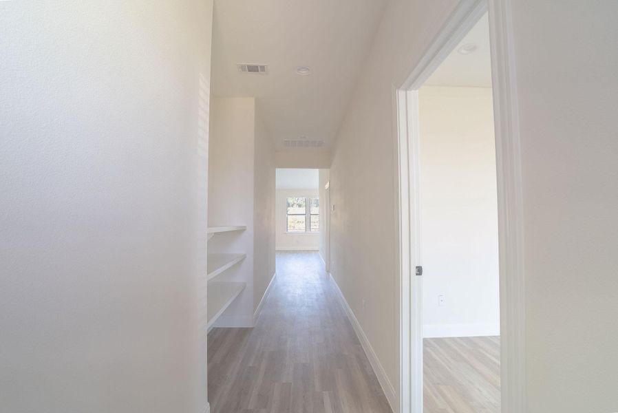 Hallway featuring light wood-type flooring and baseboards Hallway featuring light wood-type flooring and baseboards