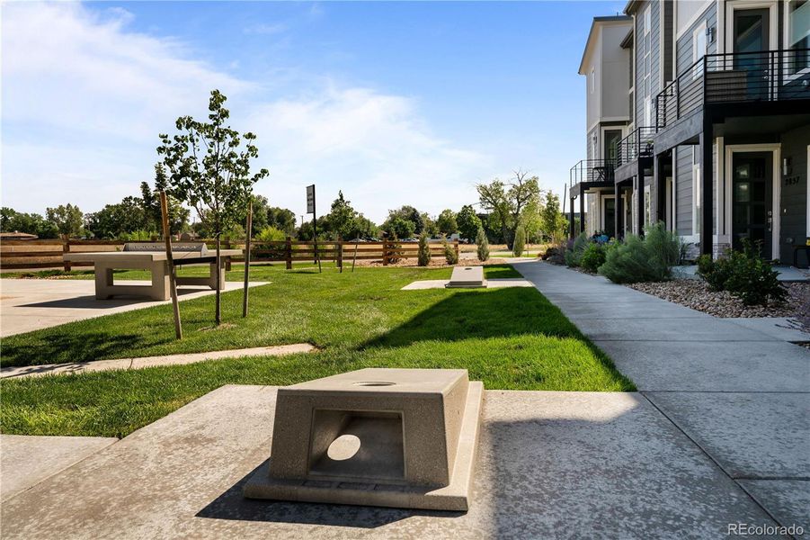 Gather with neighbors in the outdoor game area featuring picnic tables and space for activities like cornhole — ideal for casual evenings and weekend fun. Gather with neighbors in the outdoor game area featuring picnic tables and space for activities like cornhole — ideal for casual evenings and weekend fun.