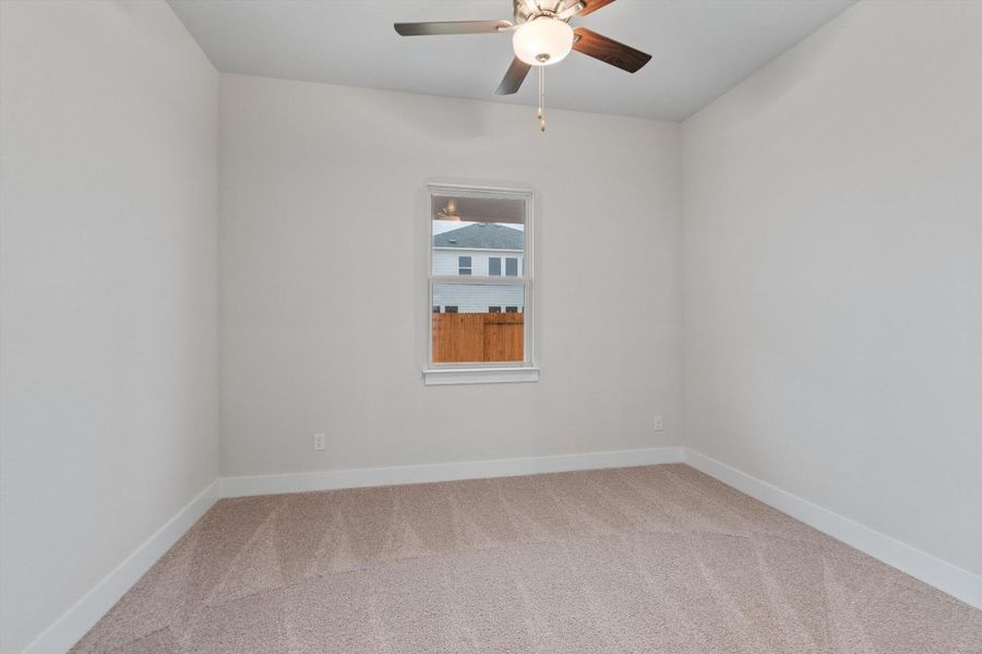A well-lit interior space with a window offering views of the neighborhood and a practical ceiling fan for comfort. A well-lit interior space with a window offering views of the neighborhood and a practical ceiling fan for comfort.
