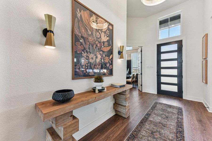 Rich wood flooring pairs with high ceilings in this welcoming entry hall.