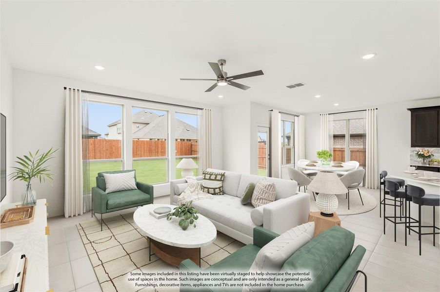 Open living room with white sofa, ceiling fan, large windows, and adjacent dining area with tile floors Open living room with white sofa, ceiling fan, large windows, and adjacent dining area with tile floors