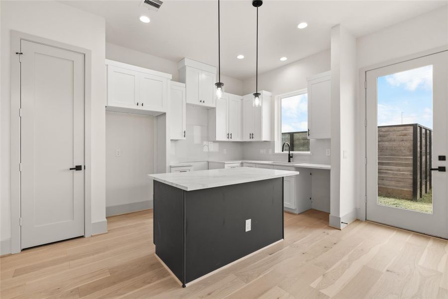 Kitchen — white cabinets, dark island, and natural light from every direction Kitchen — white cabinets, dark island, and natural light from every direction