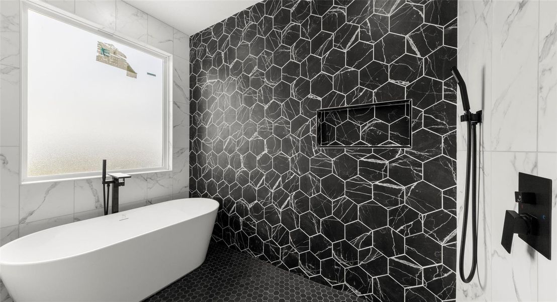 Full bathroom with tile walls, a freestanding tub, and a shower