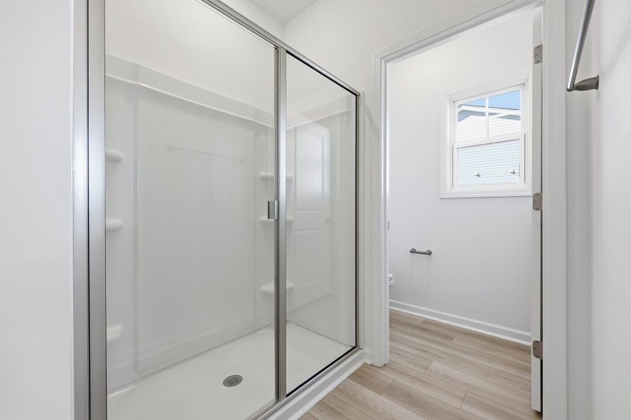 Bathroom featuring a stall shower and light wood-style flooring Bathroom featuring a stall shower and light wood-style flooring