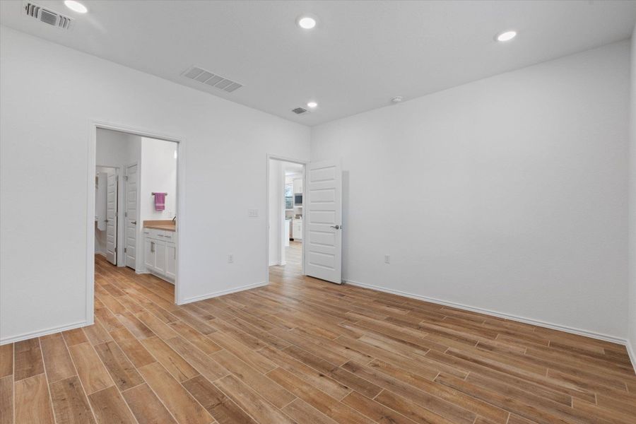 Unfurnished bedroom with recessed lighting, light wood-style flooring, and connected bathroom