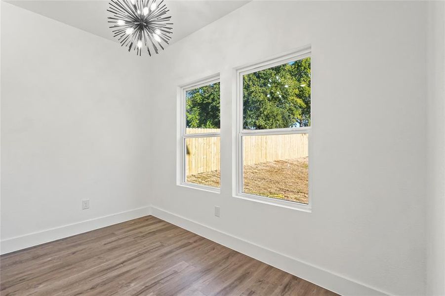 Unfurnished room featuring a chandelier and wood finished floors