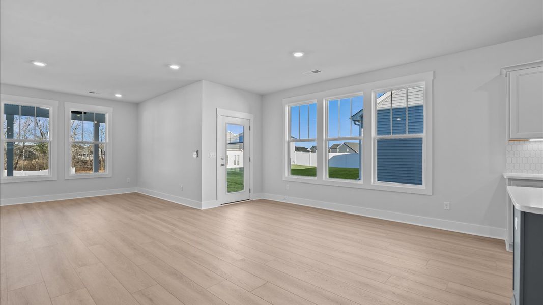 Elegant family room featuring hardwood flooring, large windows, and thoughtful architectural detail