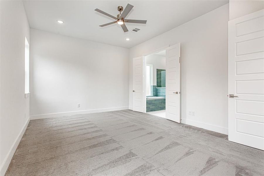 Carpeted empty room with ceiling fan