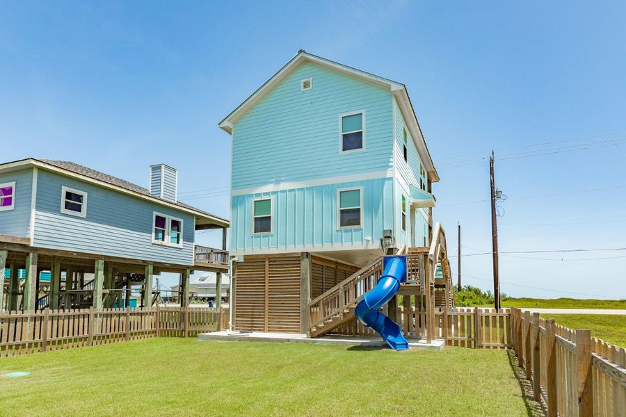 Fully fenced backyard provides plenty of green space for outdoor recreation, pets, or entertaining, complete with a fun spiral slide from the deck.