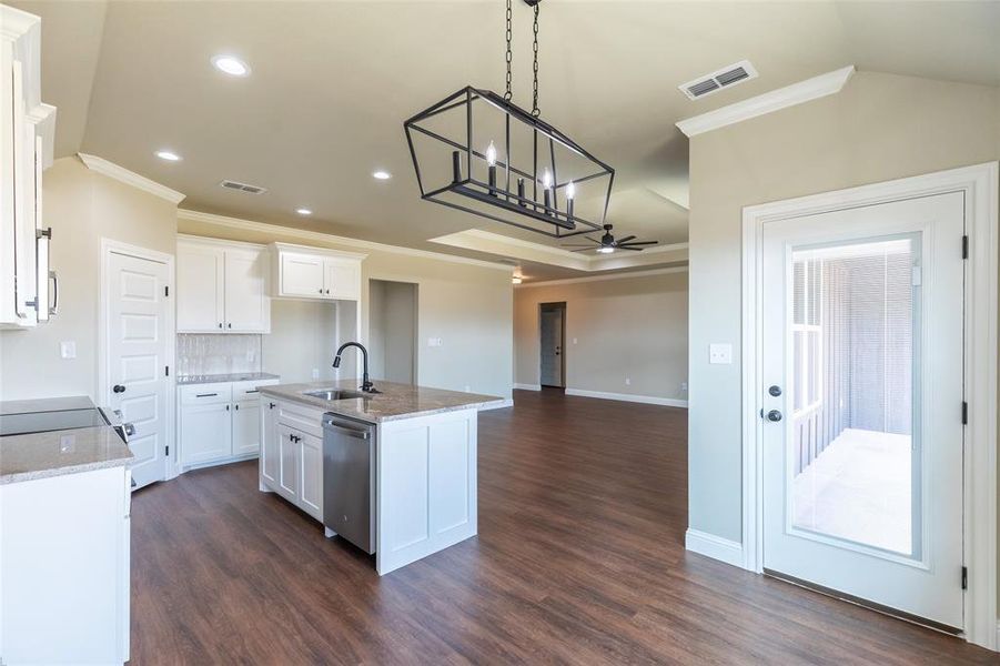Kitchen featuring wood-finish flooring, white cabinetry, granite countertops, and a full suite of stainless steel appliances