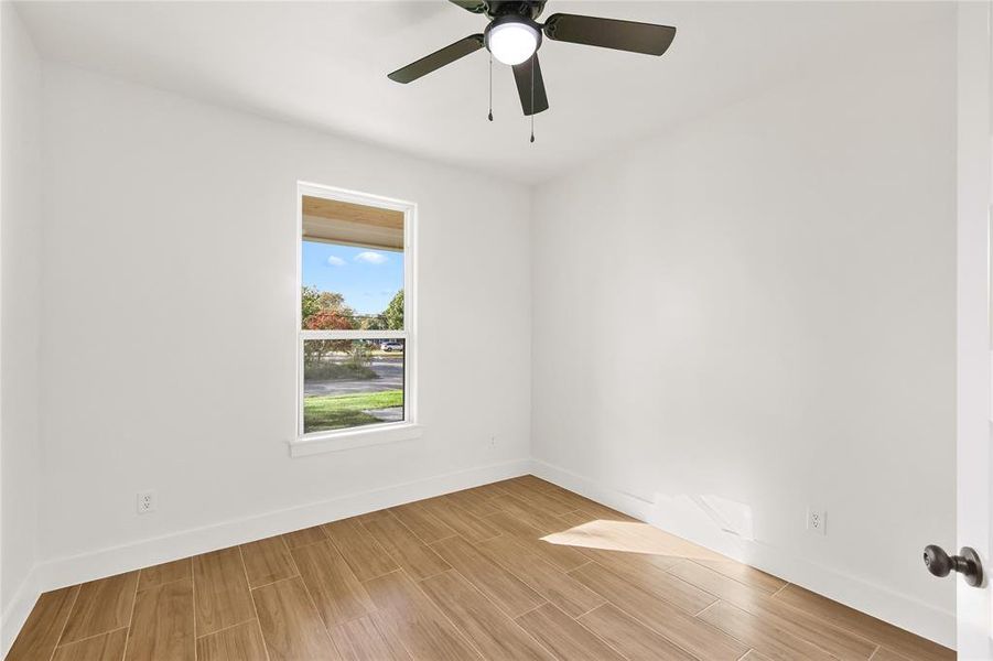 Empty room featuring wood tiled floors and a ceiling fan