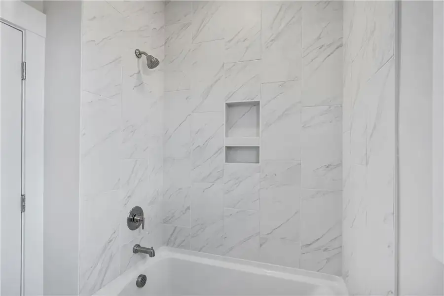A pristine bath and shower combo features elegant A pristine bath and shower combo features elegant