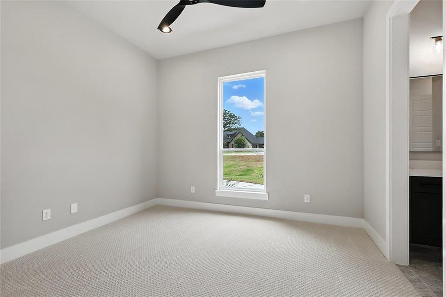 Empty room featuring light colored carpet and a ceiling fan