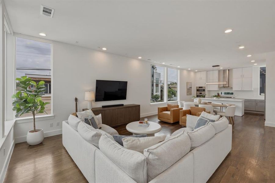 The property features an open-concept living area with hardwood floors, recessed lighting, and large windows that provide abundant natural light