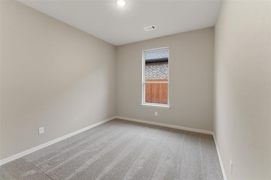 Interior room featuring neutral wall paint, gray carpet flooring, a single window, white trim, and a recessed ceiling light