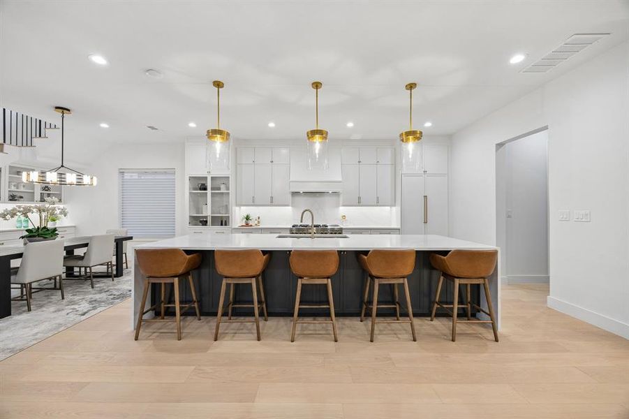 Spacious open kitchen with oversized island seating, designer pendant lighting, custom cabinetry, and seamless flow into the dining and living areas, ideal for everyday living and entertaining. Spacious open kitchen with oversized island seating, designer pendant lighting, custom cabinetry, and seamless flow into the dining and living areas, ideal for everyday living and entertaining.