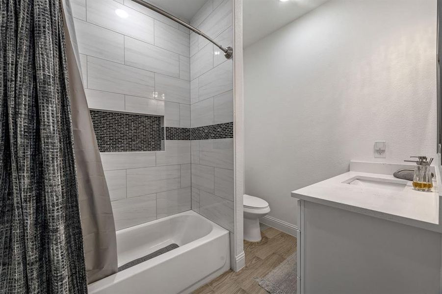 Full bathroom featuring vanity, shower / bath combination with curtain, and light wood finished floors