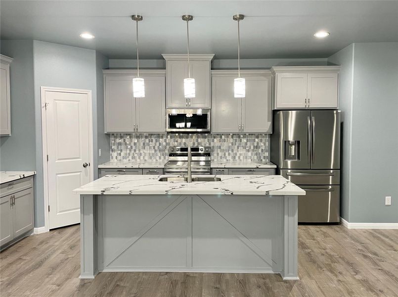 A well-appointed kitchen showcasing an inviting island and sleek stainless steel appliances.