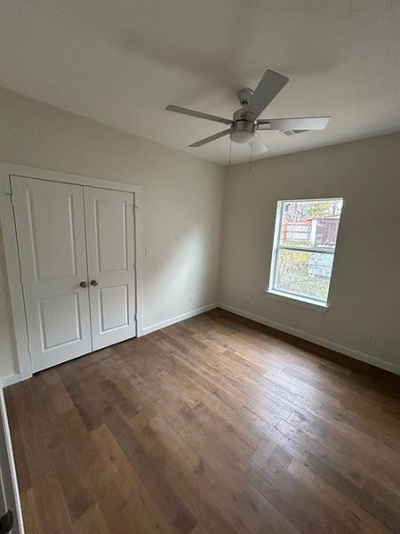 Bedroom featuring a closet, dark hardwood / wood-style floors, and ceiling fan